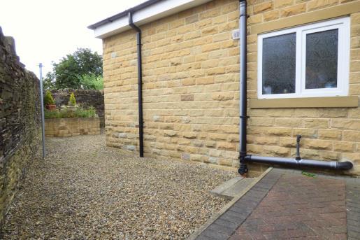 From the end of the patio is a large pebbled section running around the side and to the rear of the property.