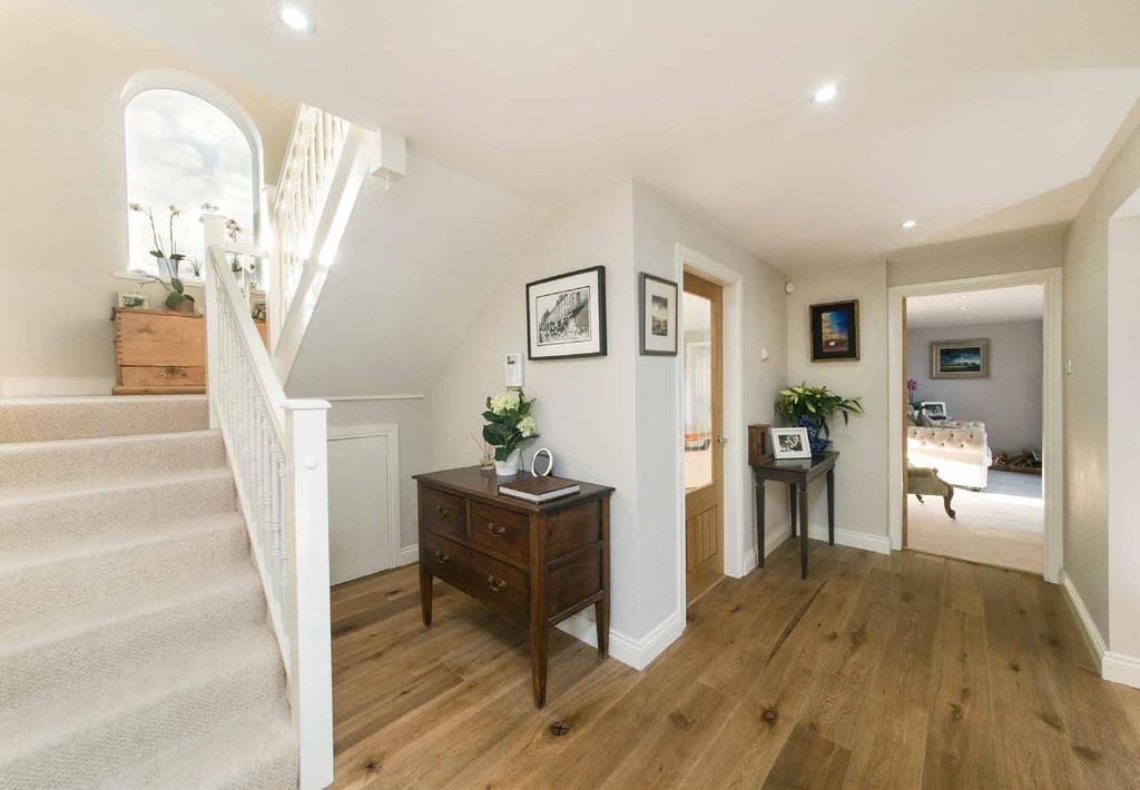Stairs lead up to the first floor landing which is flooded with natural light from the tall arched granary window.