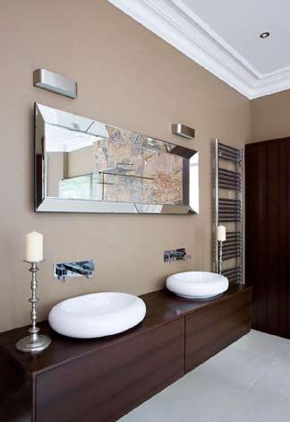 Twin wash hand basins in vanity unit. Stainless steel towel rails. Tiled floor.