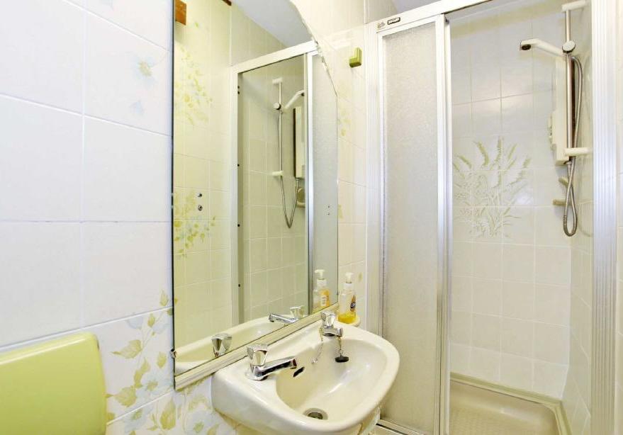 Comprising shower cubicle with electric shower, wall hung wash hand basin and WC.