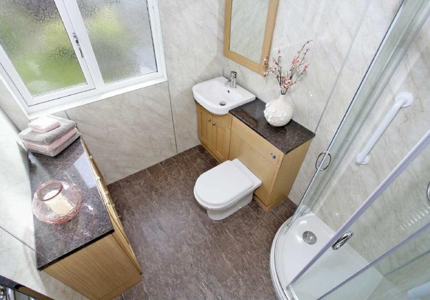 SHOWER ROOM 2.23m x 1.89m (7'4" x 6'2") Comprising a three piece suite of shower cubicle with electric shower, Wash hand basin and WC in vanity unit. Additional storage unit.