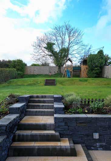To the rear is a delightful sand coloured Acheson & Glover tiled patio with slate wall and raised flowerbeds which is accessed via the Garden Room, the kitchen and the
