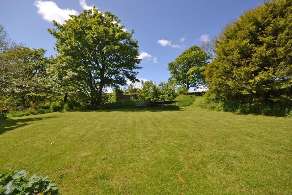 To the rear of the house is a further large area of lawn edged with beds and overlooking trees and the valley below the dam.