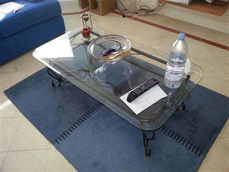 Glass coffee table with black iron frame.