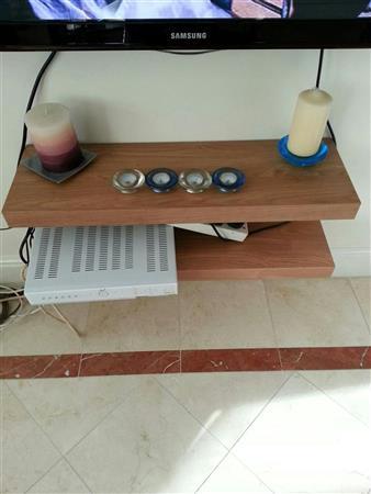 Two wooden floating shelves. Glass coffee table.