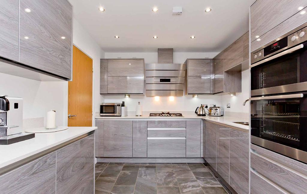 This designer kitchen is replete with a full range of AEG integrated appliances, including a fiveburner gas hob with an extractor hood, an electric double oven, a dishwasher and a