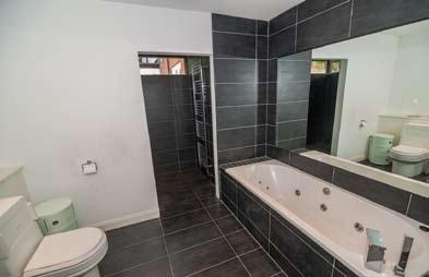 shower and extractor fan. Low flush WC. Wash hand basin with mixer tap in vanity unit.