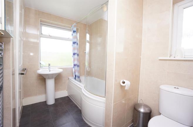 BATHROOM The spacious dual aspect bathroom comprising a white suite of bath with mains shower, pedestal wash hand basin