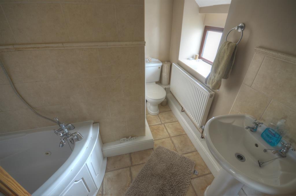 ENSUITE BATHROOM UPVC double glazed window to the rear aspect, part tiled walls, loft access, radiator, three piece suite comprising: Whirlpool spa corner bath with overhead power shower, low flush