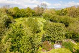 To the rear of the property is a large level lawn as well as a stone flagged patio that runs the whole length of the house and leads to a raised decked terrace outside the drawing room providing an