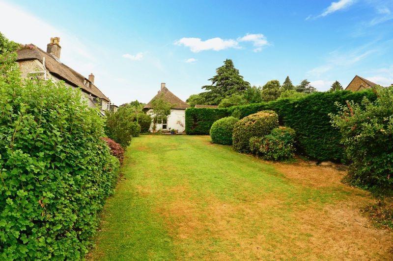 Outside The cottage is approached via a driveway and an area of parking. A wrought iron gate gives access to the pretty, enclosed front garden with lawns, mature shrubs, fir tree and hedging.