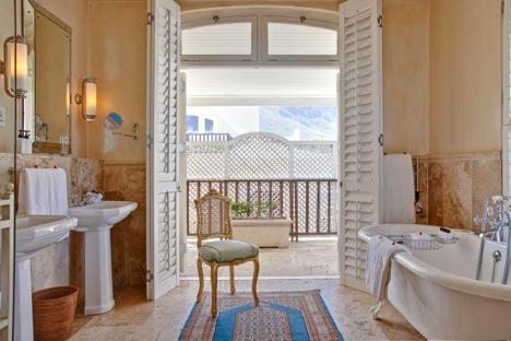 In the bathroom, shagreen-lined cupboards with double vanities surround the marble sunken bath and shower.