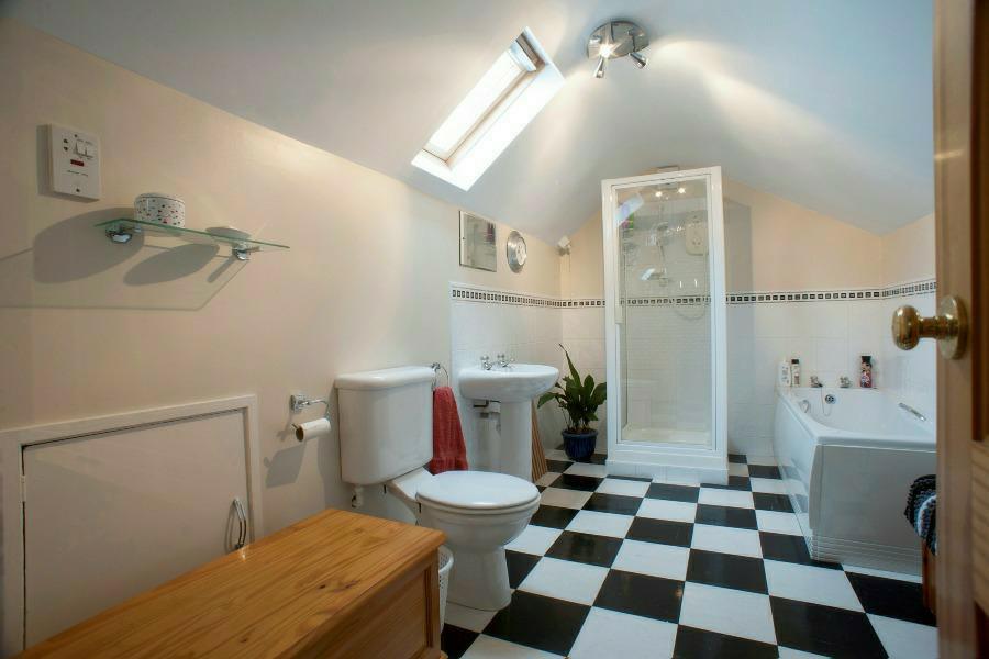 Bathroom: Comprising; panel Jacuzzi bath with tiling around, fully tiled walk in shower cubicle with electric fitting, pedestal wash hand basin, low flush WC, extractor fan.