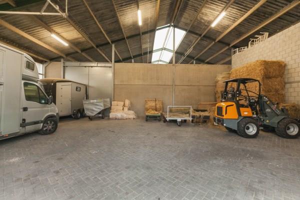 In the front part of the hall there is a large storage/machinery parking area, which is accessible from the yard through two electrically operated roller doors.