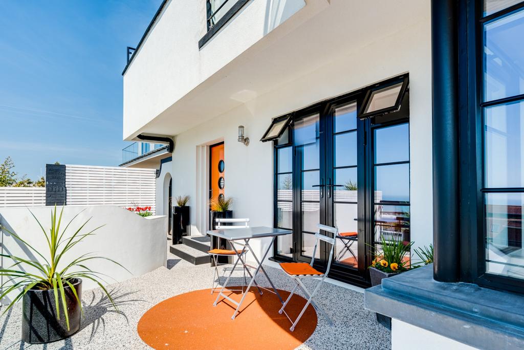 AN INTRODUCTION Art Deco inspired, this contemporary home is designed around magnificent sea views and access to a south facing landscaped garden as well as a private garden at the rear.