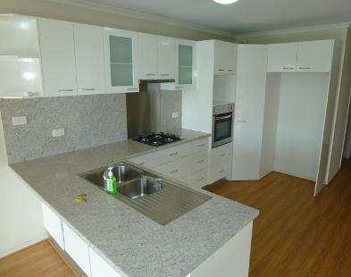 Modern kitchen has dishwasher, twin sinks, large pantry, gas