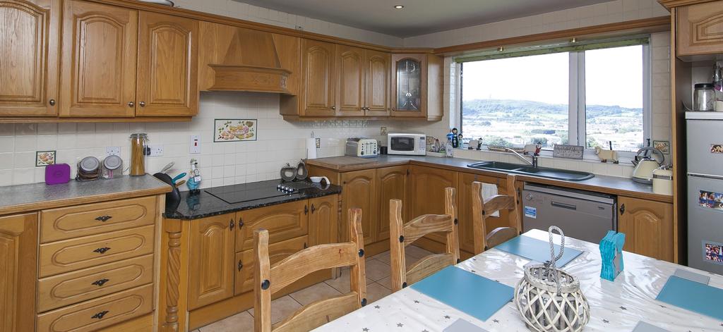 68m) Extensive range of white oak high and low level oak units and display cabinets, four ring ceramic hob with extractor above, eye level double oven, a mix of granite and laminate worktops, space