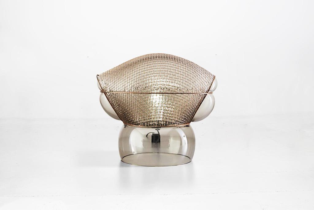 GAE AULENTI (1927-2012) Table lamp model Patroclo Manufactured by Artemide Italy, 1975 Blown glass, metal mesh 45,72 cm x 27,94 cm x 45,72h cm 18 in x 11 in x 18h in Literature Giuliana Gramigna,