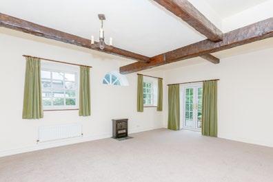 There is a spacious sitting room with three arched alcoves, a half-round cart window and French doors open onto the terrace.