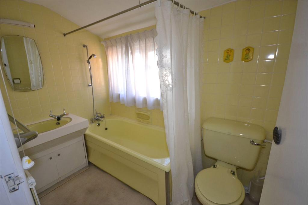 Famiy Bathroom Cooured suite comprising bath with shower attachment, wc, basin set in to unit, window to rear.