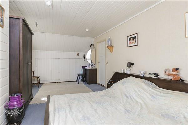 Spacious master bedroom II is carpeted, has walls that are partially covered with