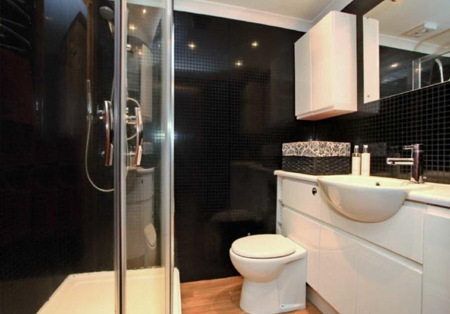 EN-SUITE Fitted with a three piece suite comprising wash hand basin and toilet pedestal in vanity unit, and corner shower cabinet. Inset halogen downlightes.