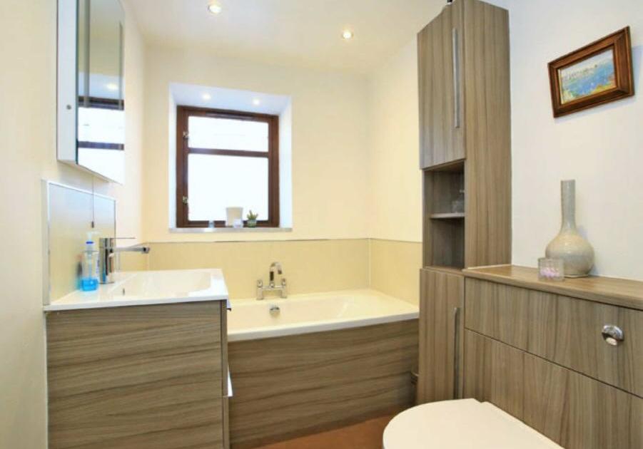 70m) Recently upgraded, this stylish Bathroom is fitted with a contemporary four piece suite comprising wash hand basin in vanity unit, toilet pedestal in vanity, bath, and corner shower cabinet.