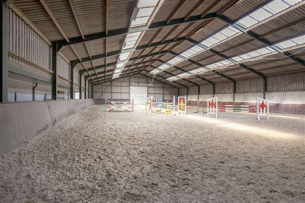 The indoor arena (about 20x45 meters) is accessible from the courtyard by a large roller door in the front.