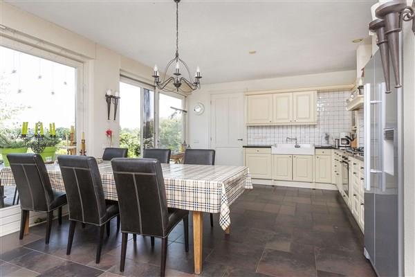 The spacious, open-plan living kitchen is furnished in country style and equipped with several