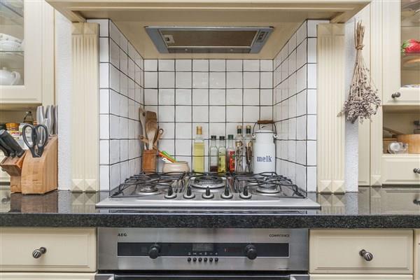 The kitchen units are equipped with granite work surfaces, a sink, a five burner hob, an oven