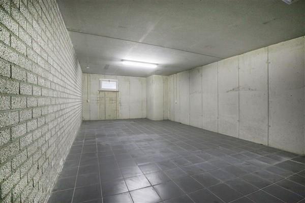 The indoor garage is situated at the right side of the house. The garage has a tiled floor with underfloor heating, masonry walls and a concrete ceiling.