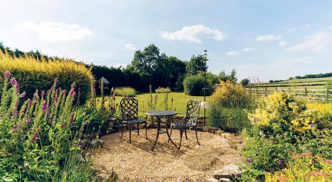 gardens are mainly laid to lawn and bordered by established hedging on one side and post and rail fencing on the other, making the most of the surrounding views.