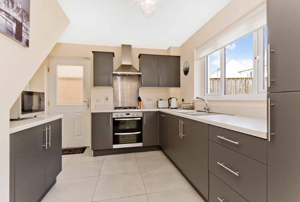 Leading off the reception area is a bright, contemporary kitchen fitted with a wide selection of stylish matt-grey cabinets paired with chrome accents and quality hardwearing worktops.