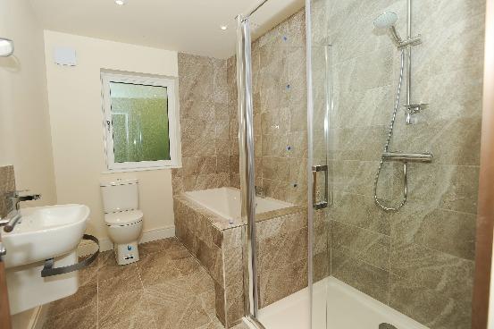 BATHROOM Luxurious white suite comprising recessed bath in tiled surround with raised pillar mixer taps; dual flush wc; semi pedestal wash