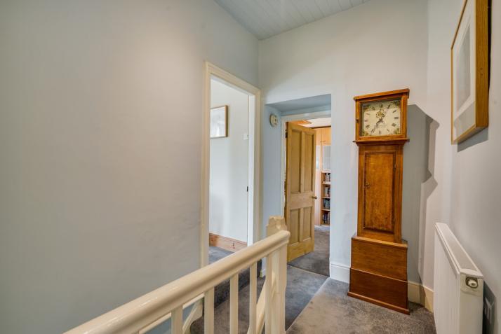 Polished wood floor, two radiators and understairs alcove. Door to inner hall and door to: Sitting Room 15' 8" x 9' 4" (4.78m x 2.84m) a cosy room with polished wood floor and painted ceiling beams.