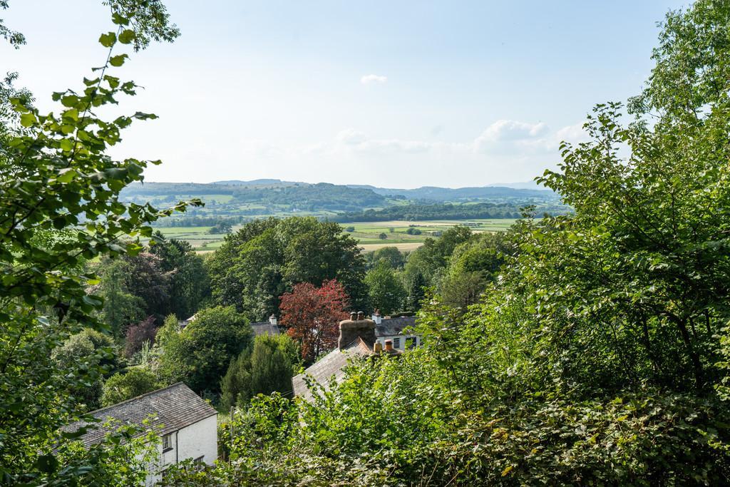 Outside: The property stands on a large elevated plot set below the limestone scar of Crag Mollet with the most delightful landscaped gardens including a formal lawned garden with paved patio areas,
