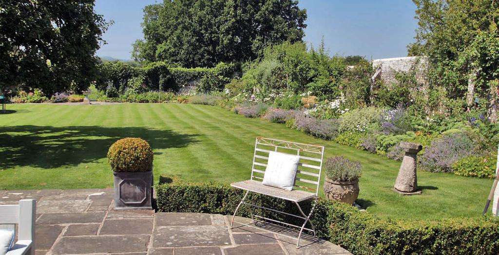 A York stone terrace adjoins the house, from which steps descend to an area of lawn with a prolific apple tree, edged by wellstocked shrub and flower borders which produce an array of colour in the