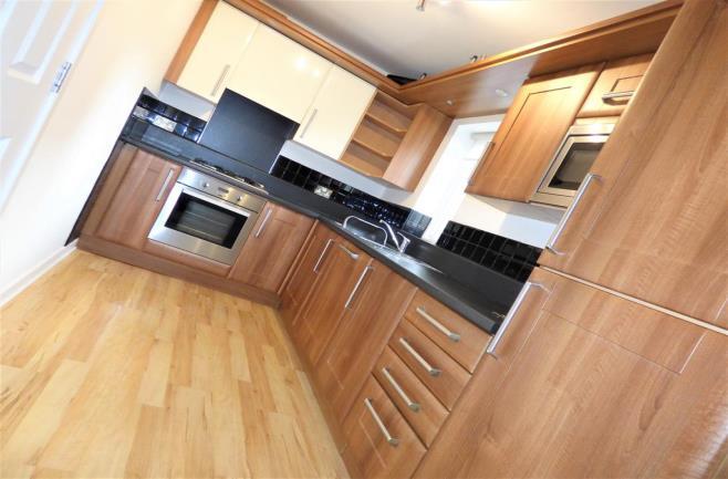 KITCHEN 3.18m (10' 5") x 1.96m (6' 5") Having a range of modern units with the doors being finished in a wrapped oak effect, with brushed chrome contemporary handles.