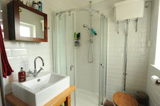 SHOWER ROOM: Fully tiled shower cubicle with Aqualisa shower unit, wash stand, high flush