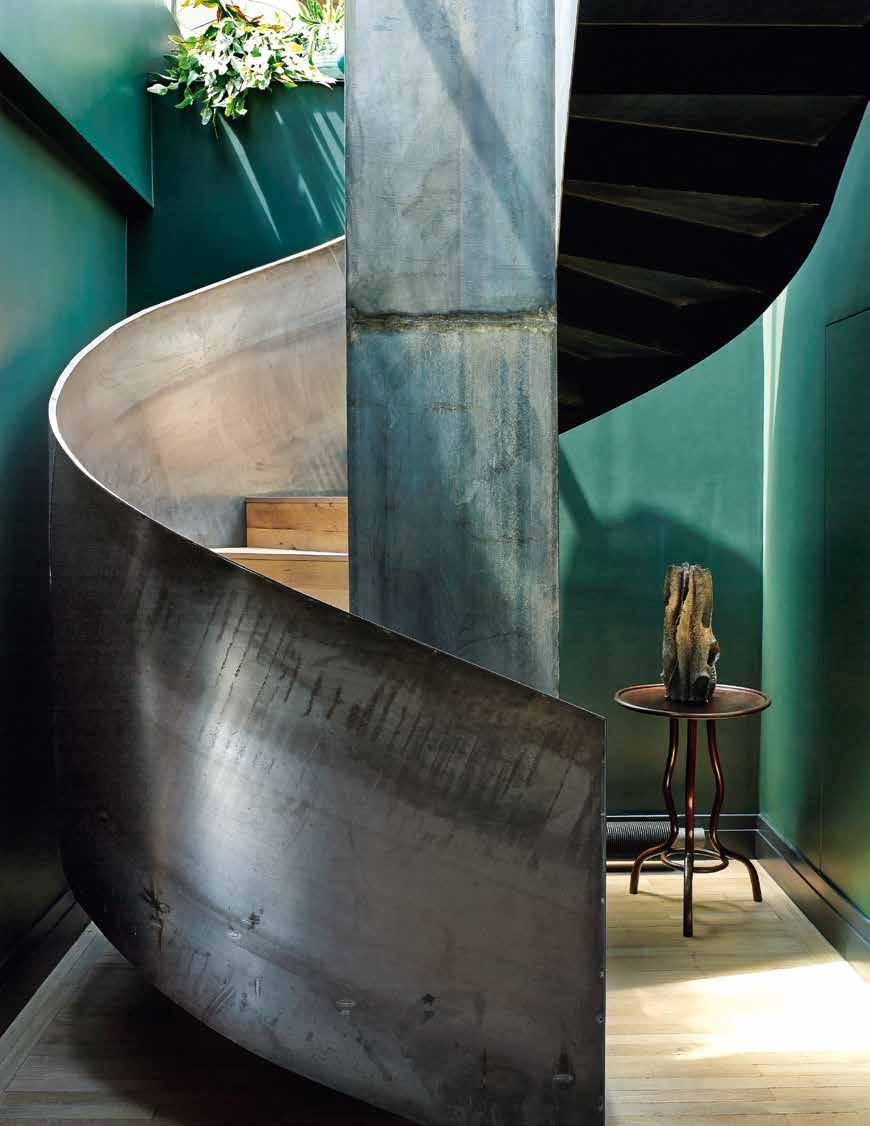 OPPOSITE: In the darkly painted entryway, bathed in vivid daylight, the staircase winds up to the living room and terrace. Wall paint by Farrow & Ball. Details, last pages.