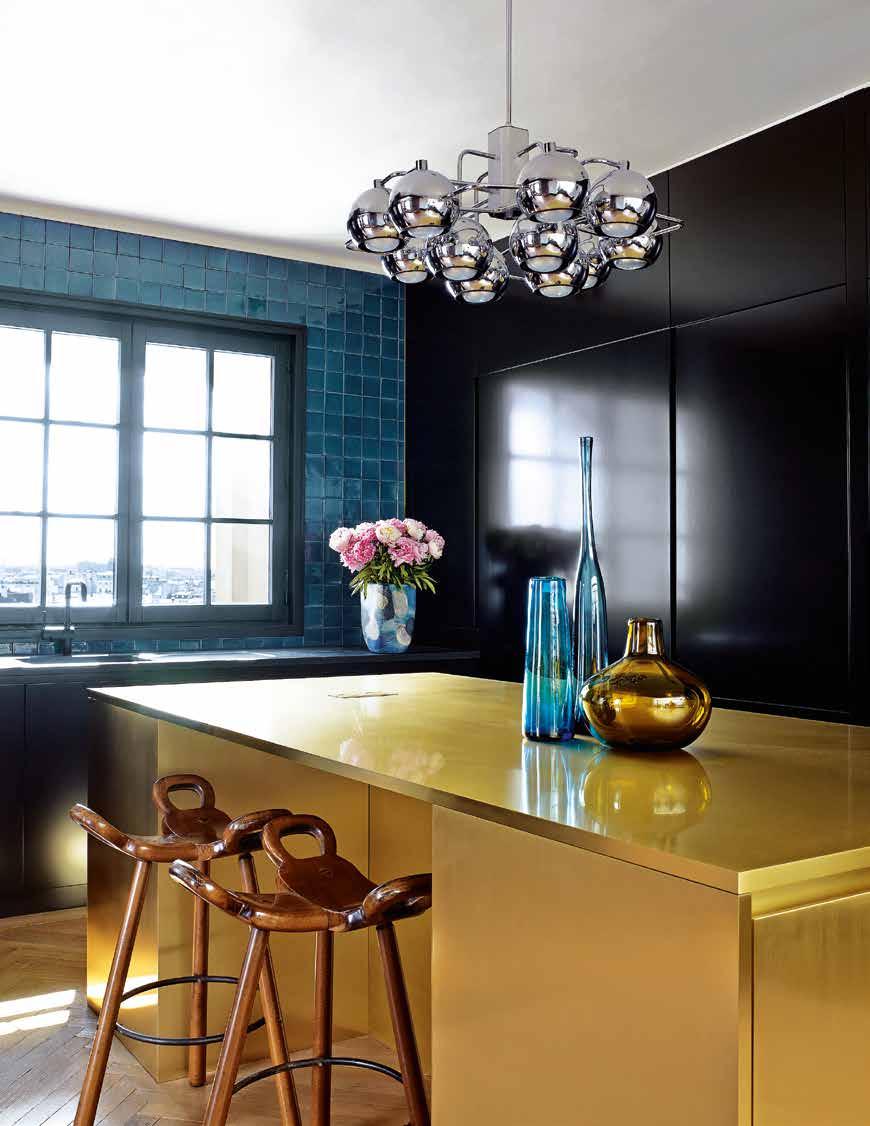 The kitchen is conceived around a gold-hued island designed by Studio KO, which contrasts with the black lacquer joinery. The Spanish bar stools, like the vintage pendant, were lucky secondhand finds.