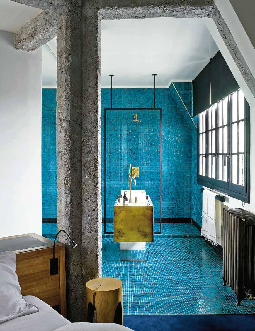 Inspired by an Oriental bathhouse, the ensuite is lined with blue-andgold mosaics tiles from Bisazza.