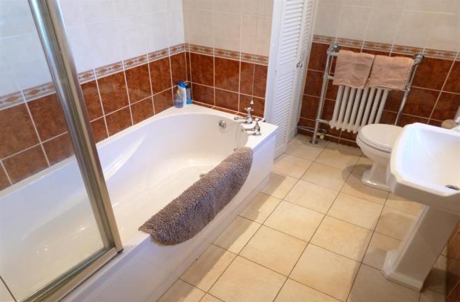 0m (6' 7") Five down lights to the ceiling, double glazed window to the rear elevation, low flush WC, pedestal wash basin, panelled bath with shower over and glass side screen,
