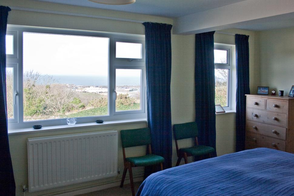 MASTER BEDROOM 17ft 5" x 10ft 6" Two north facing upvc double glazed windows, with curtains and rails, with wonderful views to Braye Bay.