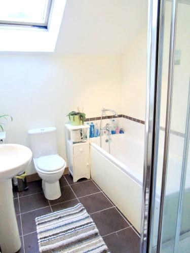 Bathroom: comprising; panel bath with mixer shower over, tiling around, low flush WC, pedestal wash hand basin, tiled splash back,