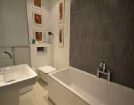 BATHROOM A modern bathroom comprising of panelled bath with stainless steel mixer tap and shower over with shower door, wall-hung wash hand-basin with stainless steel mixer tap and low-flush w.c. Built-in storage cupboard.