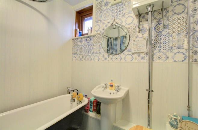 BATHROOM 1.85m (6' 1") X 1.80m (5' 11") Free standing cast iron bath. Sink. WC. Partially tiled. Window overlooking rear aspect.
