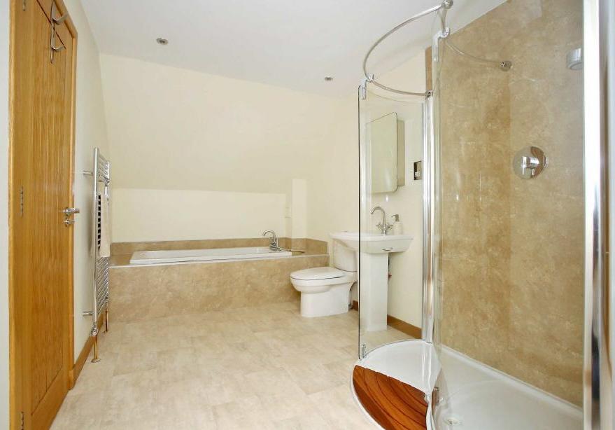 EN SUITE BATHROOM Comprising a large bath, WC pedestal wash hand basin and curved shower cubicle, this is a