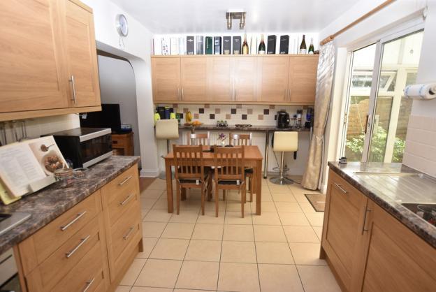 under. Integrated dishwasher. Extensive range of wall and base units with work surface over. Breakfast bar.