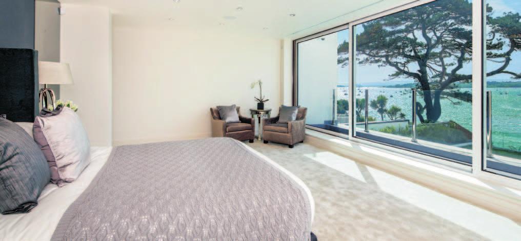 The sumptuous master bedroom suite enjoys commanding harbour views through full height